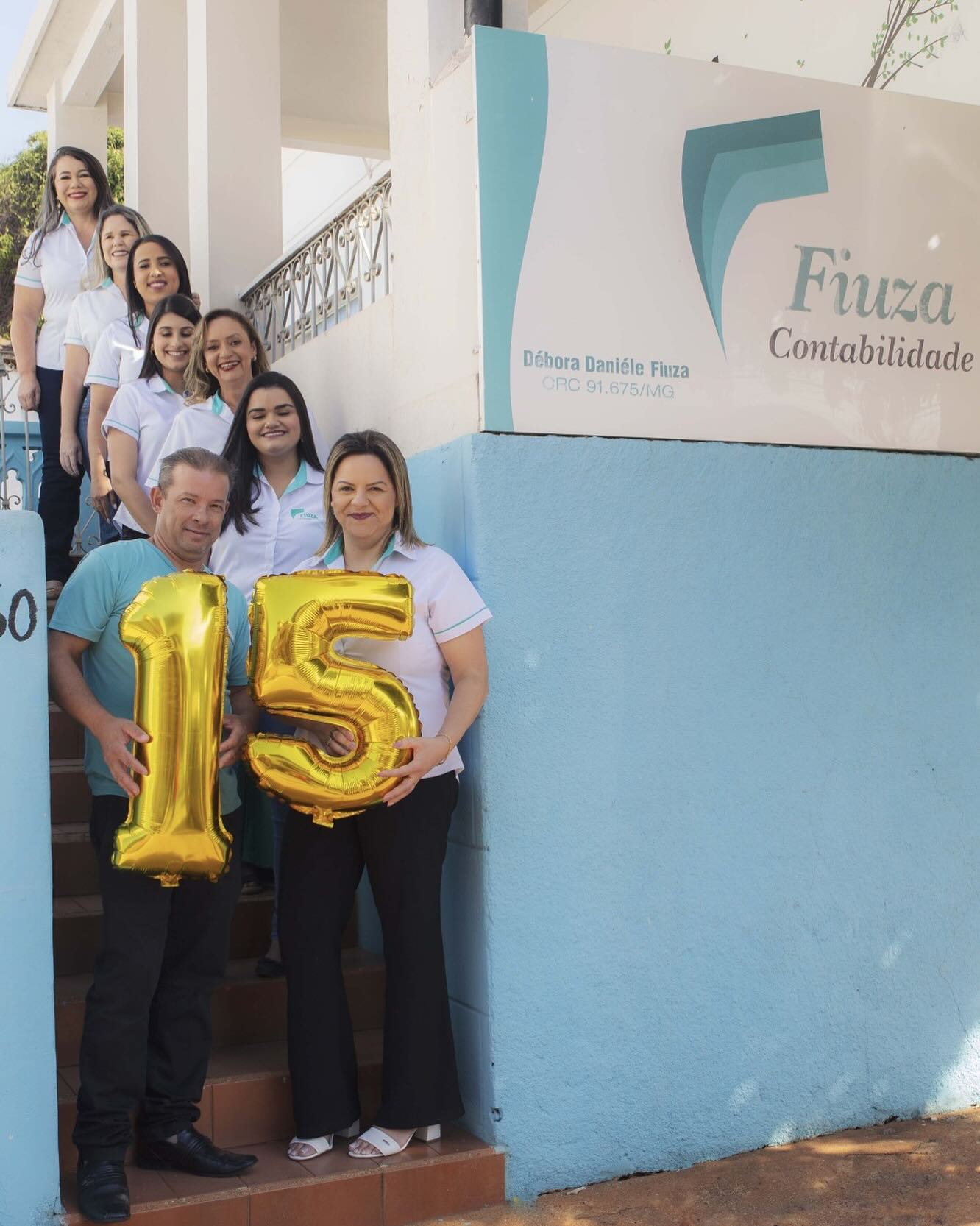 Débora e equipe na celebração dos 15 anos da Fiuza, em frente ao escritório
